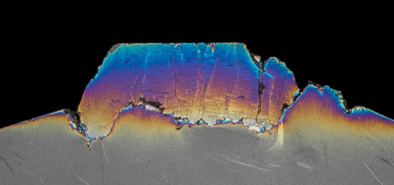 Microscopic cross section of a steel edge showing blue discoloration indicating a destructive heat affected zone Microscopic cross section of a steel edge showing blue discoloration indicating a destructive heat affected zone
