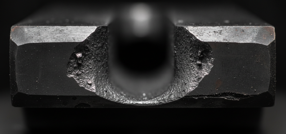 Magnified hardened steel gating channel severely eroded by the continuous flow of molten metal Magnified hardened steel gating channel severely eroded by the continuous flow of molten metal