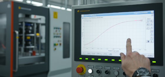 Operator adjusting 100-point parison wall thickness programming curve on a blow molding machine control panel Operator adjusting 100-point parison wall thickness programming curve on a blow molding machine control panel