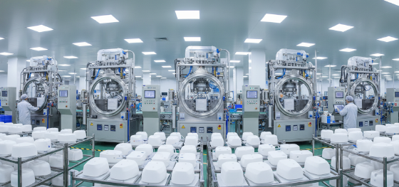 Expansive production floor featuring multiple automated vacuum chambers curing medical grade device enclosures